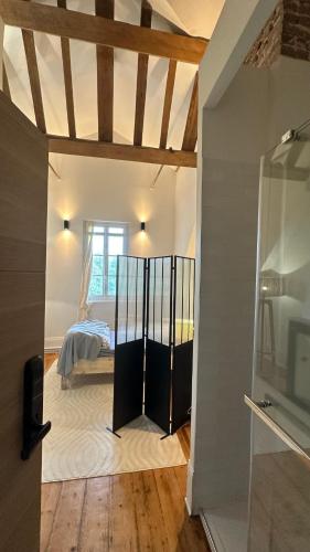 a bedroom with a bed in a room with a window at Chateau Loyd & Spa Normandie Pays de Caux in Veauville-les-Baons
