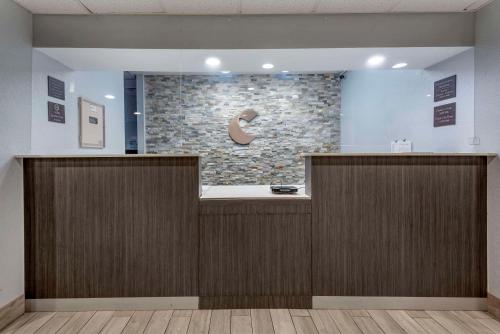 a reception desk in a lobby with a stone wall at Comfort Inn & Suites Liverpool - Syracuse in Liverpool