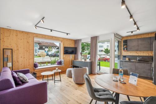 a living room with a purple couch and a table at Chalet LebensTraum im Zentrum in Oberstaufen