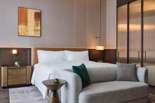 a hotel room with a bed and a couch at Conrad Chongqing - Indulge in the magical 8D city landscape in Chongqing