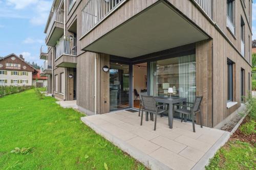 a patio with a table and chairs in front of a building at Chalet LebensTraum im Zentrum in Oberstaufen