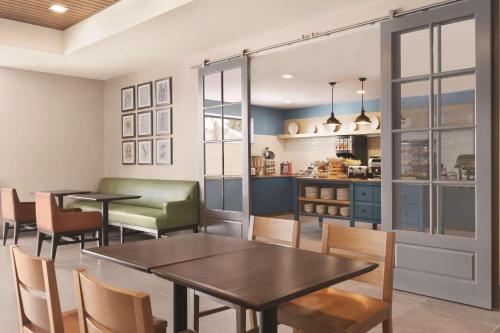 a dining room with tables and chairs and a kitchen at Country Inn & Suites by Radisson, Belleville, ON in Belleville