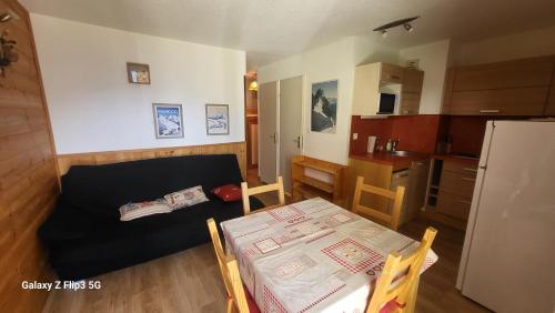 Ce petit appartement comprend une table et une cuisine. dans l'établissement MONT BLANC Soleil C-4, à Manigod