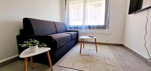 un salon avec un canapé bleu et une table dans l'établissement 3 Le Saint Joseph studio in city center of Antibes with AC, à Antibes