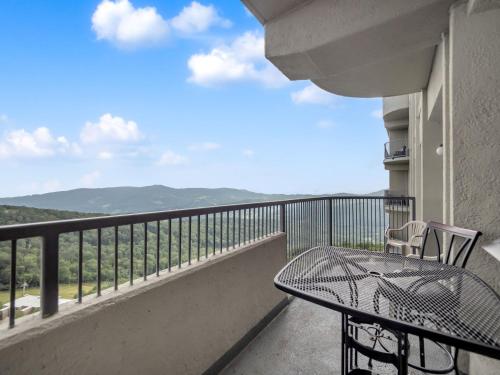 a balcony with a table and chairs and a view at Uhost AI - 2BR 2BA Suite with Balcony - 6 Sleeps in Sugar Mountain