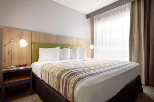 a large bed in a hotel room with a window at Country Inn & Suites by Radisson, Seattle-Bothell, WA in Bothell