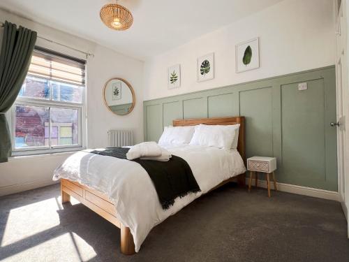 a bedroom with a large bed with a green headboard at Your Property Box Short Stays - Severn Street in Worcester