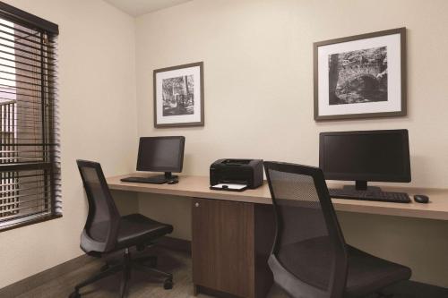 a desk with two computer monitors and two chairs at Country Inn & Suites by Radisson, Seattle-Bothell, WA in Bothell