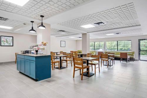 a dining room with tables and chairs and windows at Country Inn & Suites by Radisson, Pickerington, OH in Pickerington
