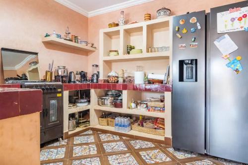 a kitchen with a stainless steel refrigerator and shelves at VILLA GIULIA & SOLEY in Douar Sidi Ayad