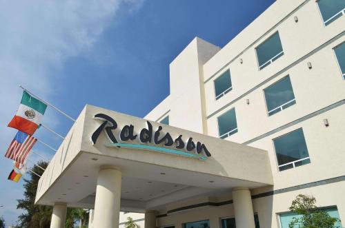 a building with a sign on top of it at Radisson Poliforum Plaza Hotel Leon in León
