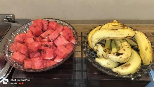 a bowl of watermelon and a bowl of bananas at Aamantran Residency Hotel, Sohna Road, Sector 49, Gurugram in Gurgaon