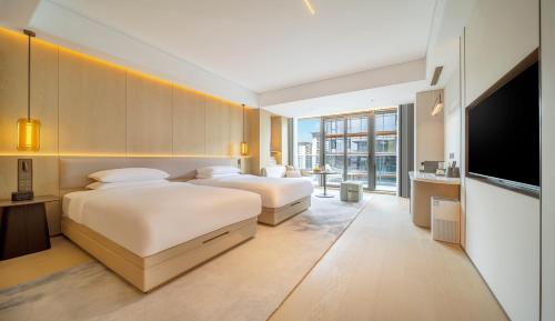 Postel nebo postele na pokoji v ubytování New Century Mansion Resort Hangzhou Xianghu Baoyi