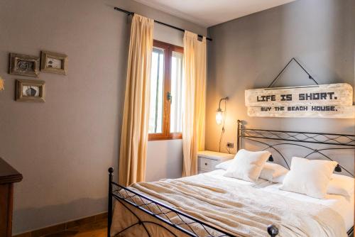 a bedroom with a bed with a sign on the wall at CASA OSALA in Orosei
