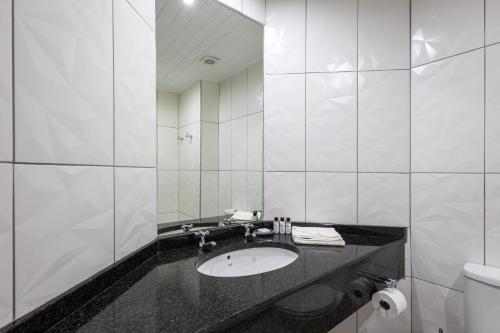 a white bathroom with a sink and a mirror at Knysna Log-Inn Hotel in Knysna