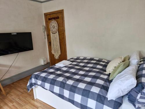 a bedroom with a black and white checkered bed at Bright Studio Apartment in a perfect location in London
