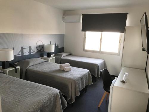 a hotel room with two beds and a window at Hotel Central in Durazno