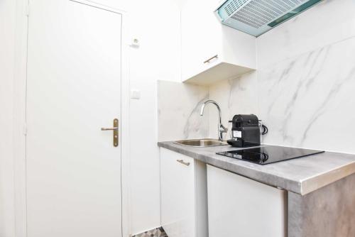 une petite cuisine avec un évier et une fenêtre dans l'établissement Cosy studio - 2P - Voltaire, à Paris