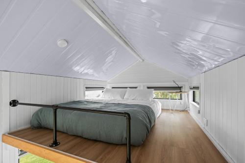 a bed in the middle of a bedroom in a tiny house at Sacred Ground by Tiny Away in Okato