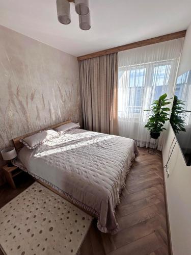 a bedroom with a bed and a large window at Apartamenty Termal Water Długa 9 m31 in Uniejow