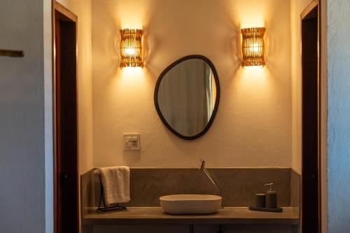 a bathroom with a sink and a mirror on the wall at Amigos do Vento Chalés e Kite Point in Touros