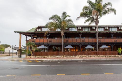 a building with palm trees in front of a street at Knysna Log-Inn Hotel in Knysna
