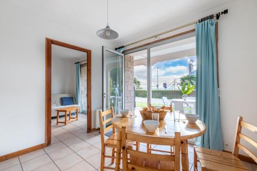 une salle à manger avec une table et des chaises et une grande fenêtre dans l'établissement Vue mer - Emplacement exceptionnel, à Pléneuf-Val-André