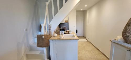 La salle de bains est pourvue d'un lavabo et d'un couloir avec un escalier. dans l'établissement La Romantique Villa, au Grau-du-Roi