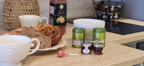 une table avec une assiette de pain et des tasses à café dans l'établissement La Romantique Villa, au Grau-du-Roi