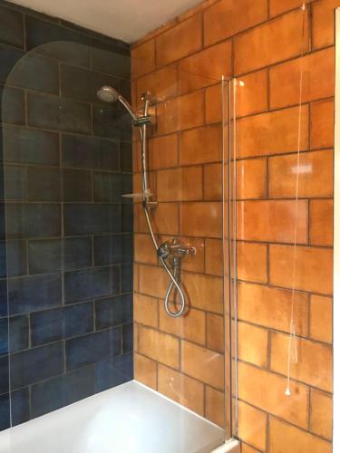 a shower in a bathroom with a brick wall at River Airebnb in Bradford