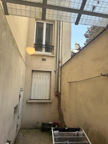 une allée vide avec un bâtiment et une fenêtre dans l'établissement Appartement Paris 18, à Paris