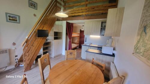 une cuisine et une salle à manger avec une table et des chaises en bois dans l'établissement Pan 415A, à Manigod