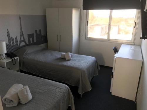 a hotel room with two beds and a window at Hotel Central in Durazno