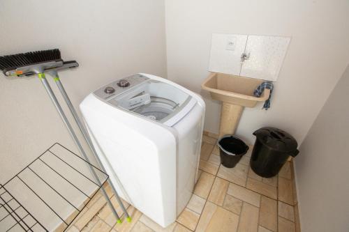 a small bathroom with a washing machine and a toilet at Jahu Center Village in Jaú