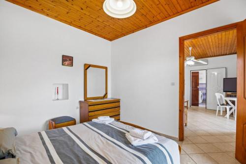 a bedroom with a bed with a dresser and a mirror at Nick's Apartment in Kambos in Kámbos