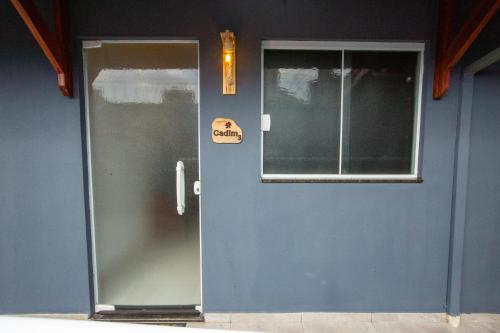 a blue door with a sign on it next to a window at Jahu Center Village in Jaú