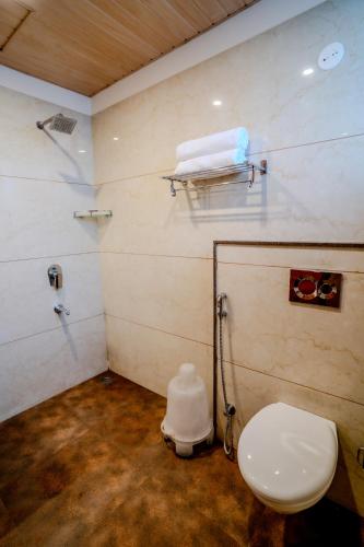 a bathroom with a toilet and a sink in a room at Hotel Amantran Inn - City Centre in Udaipur