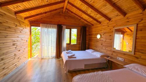a bedroom with two beds in a wooden cabin at Gaia bungalow in Ayvalık