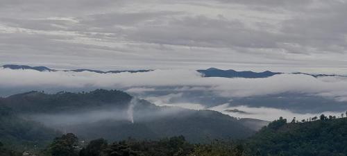 a view of a mountain with clouds in the valley at KHIRI HOUSE &Café Farm ดอยช้างเชียงรายที่พักอาข่าเรียวกังสไตล์กลางหมู่บ้านดอยช้าง in Ban Rong Than