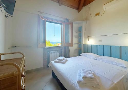 a bedroom with a white bed and a window at Solemar Sicilia - Residence Mer et Soleil in Bagheria
