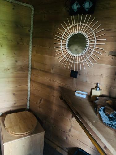 une salle de bain avec toilettes et miroir dans l'établissement Cabane dans les Arbres de Valmo'Insolite, à Valmorel