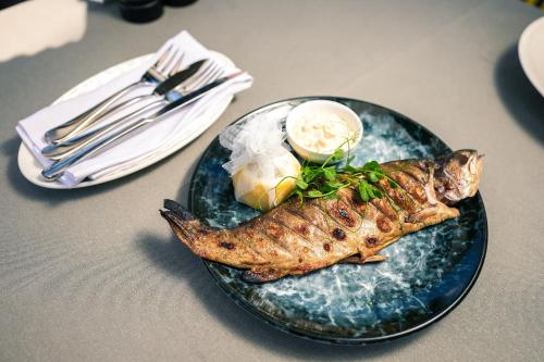 a plate of food with fish on a table at Yaremche Club Hotel in Yaremche