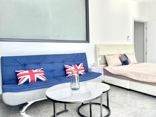 a living room with a blue couch and a table at AIR Condominium & Residence - Sihanoukville - 5mn to boat pier in Sihanoukville