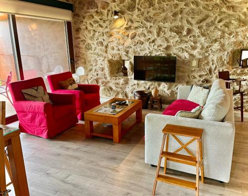 a living room with two couches and a tv at Casa da Mina - Eido do Pomar in Arcos de Valdevez