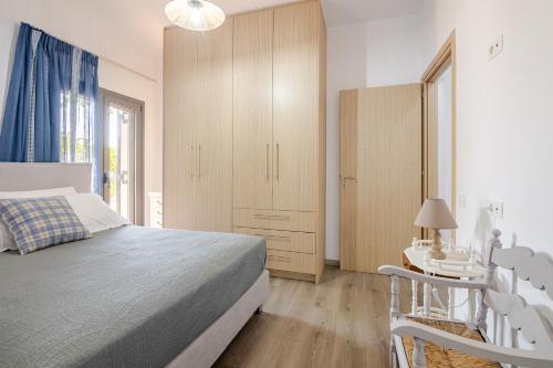 a bedroom with a bed and a night stand and a table at Aurora Spinalonga Garden Cottage in Chavgas