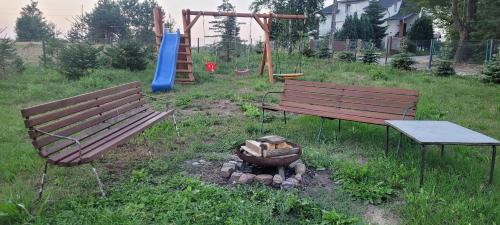 two benches and a fire pit in a park at Apartament w małej wsi niedaleko jezior - Kaszëbsczi Nórcëk in Kamienica Szlachecka