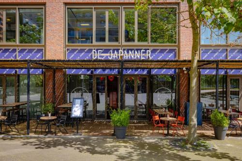 a building with tables and chairs in front of it at Crowne Plaza Amsterdam - South by IHG in Amsterdam