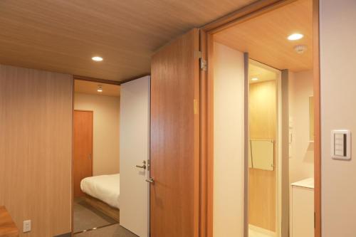 大阪市にあるOYASUMI Ice&Hotel 大阪難波 なんばのベッドルームにつながるドア付きの部屋