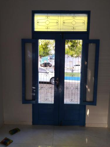 a blue door with two windows in a building at Pousada Nelly Medeiros in Carolina