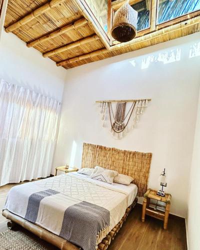 a bedroom with a large bed and a wooden ceiling at IGUANA HOUSE in Máncora